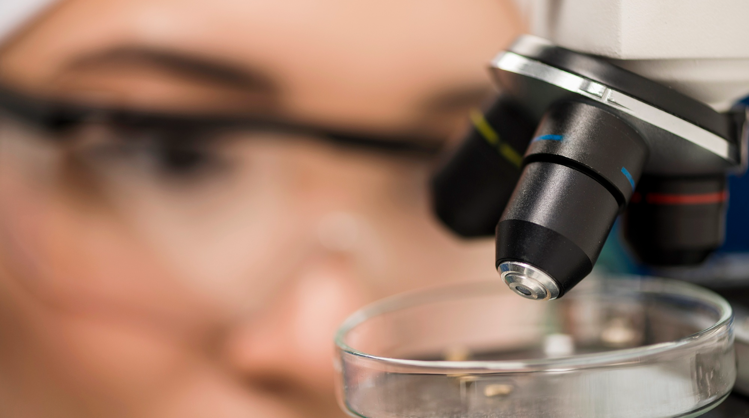 Microscope positioned over a petri dish in a research laboratory